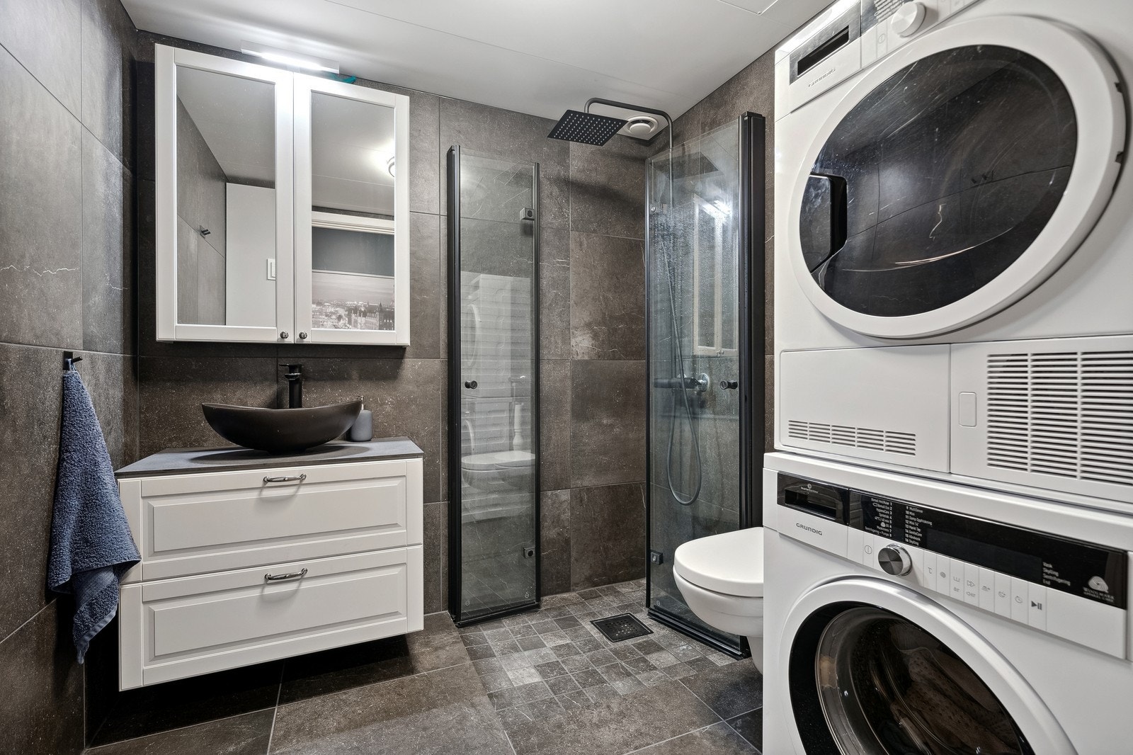 Lekkert flislagt baderom med vaskemaskin og tørketrommel som medfølger. Galleribilde