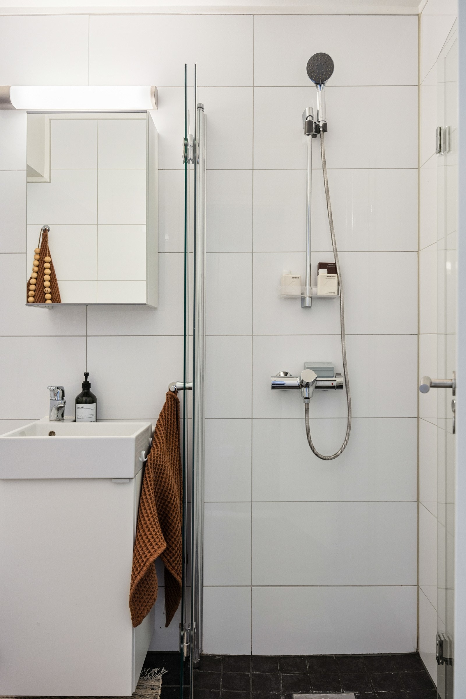 Baderommet er utstyrt med servantskap, speilskap med belysning over, dusjhjørne med innfellbare glassdører og gulvstående toalett. Galleribilde