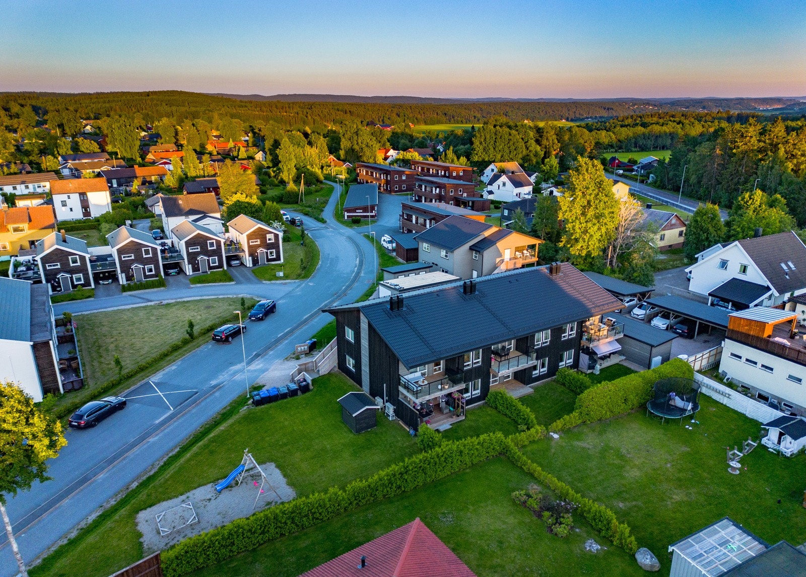 Dronebilde som viser området hvor eiendommen ligger. Fellesarealer med grøntområde og lekeplass Galleribilde