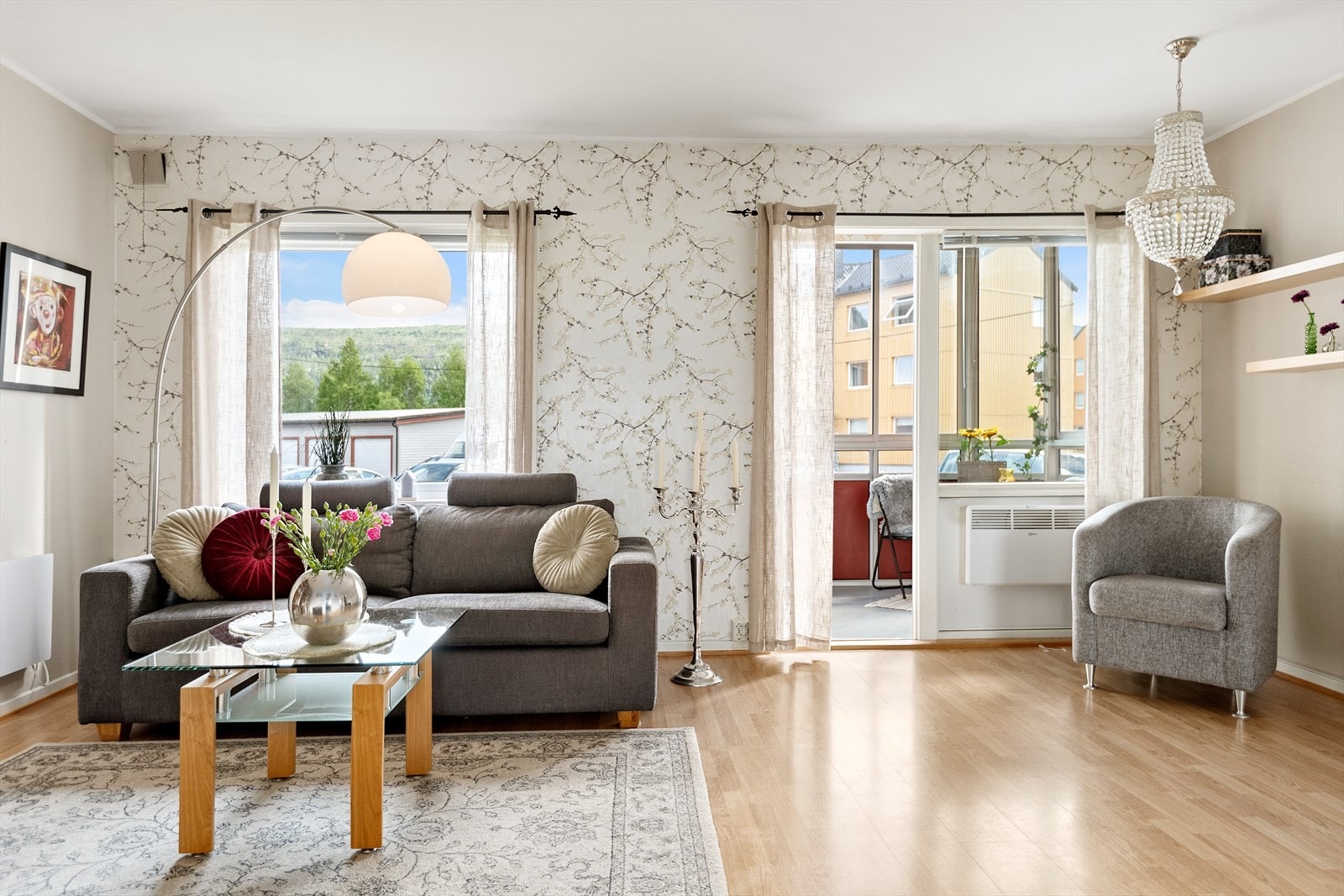 Veggflater er en kombinasjon av lysmalt strie og floral tapet. Gulvet har en lys laminat. Galleribilde