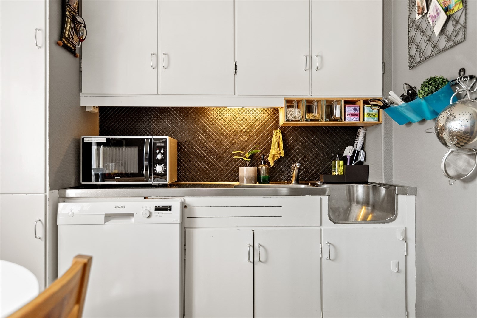 Rommet er i koselig utførelse med sjakkrutet belegg på gulv og veggfarge i lun brungrå tone. Hvitevarer som komfyr, oppvaskmaskin og kjøleskap medfølger i Hanselen. Galleribilde