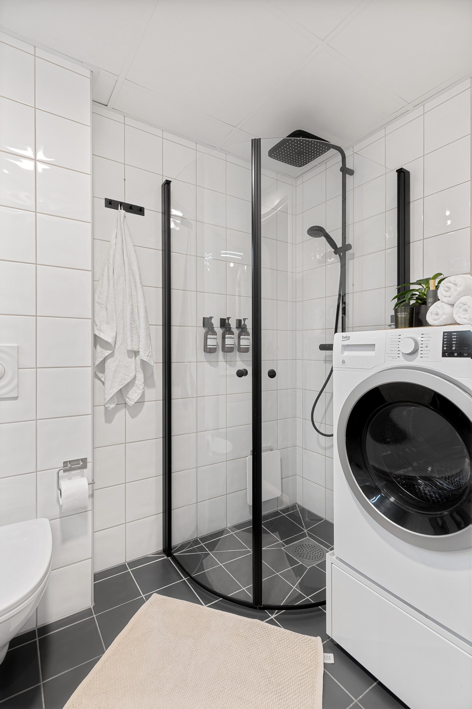 Badet er innredet med varmekabler i gulv, vegghengt toalett, dusjvegger og servantinnredning med speilskap over servant. Det er for øvrig opplegg for vaskemaskin og tørketrommel. Galleribilde