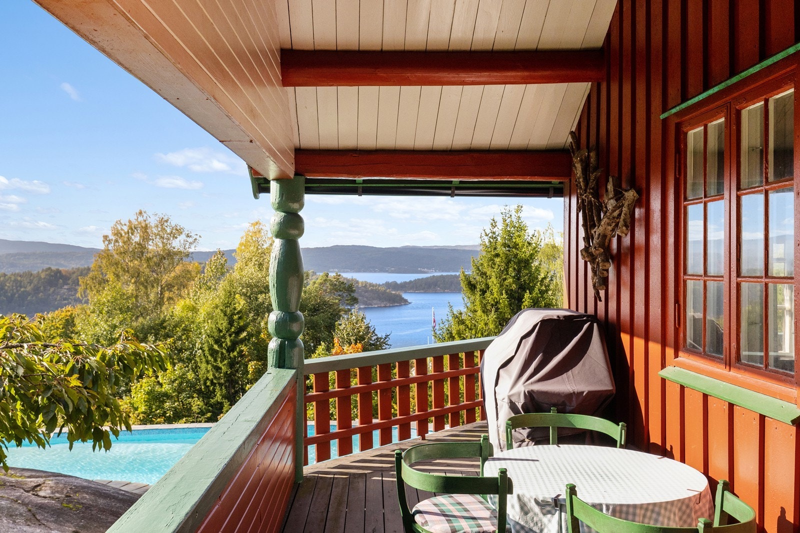 Overbygget terrasse med fjordutsikt og oversikt over svømmebassenget. Galleribilde