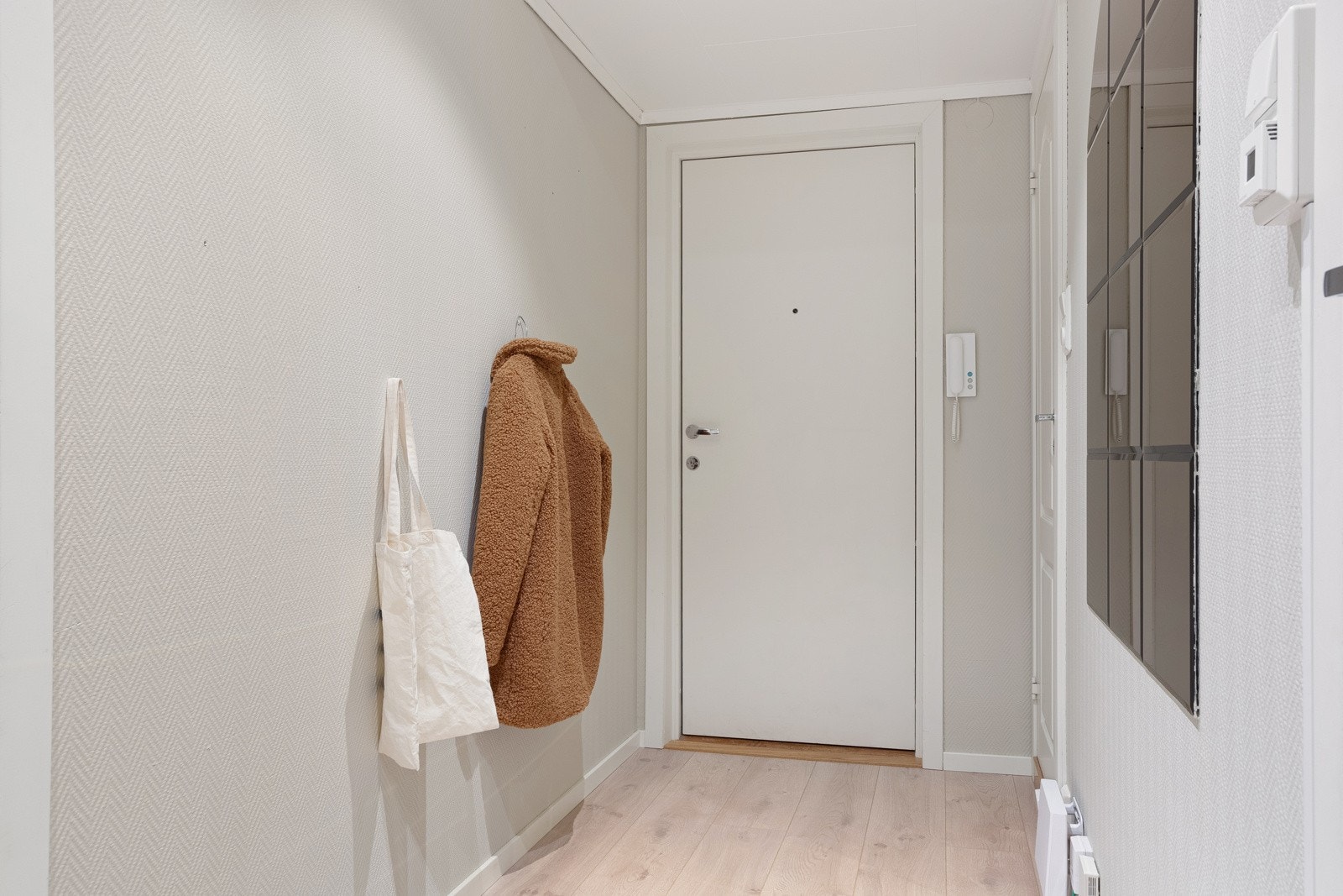Velkommen inn. Entreen måler 5,1 kvm og gir et lunt førsteinntrykk med lyst 1-stavs laminat som er gjennomgående i alle rom. Galleribilde