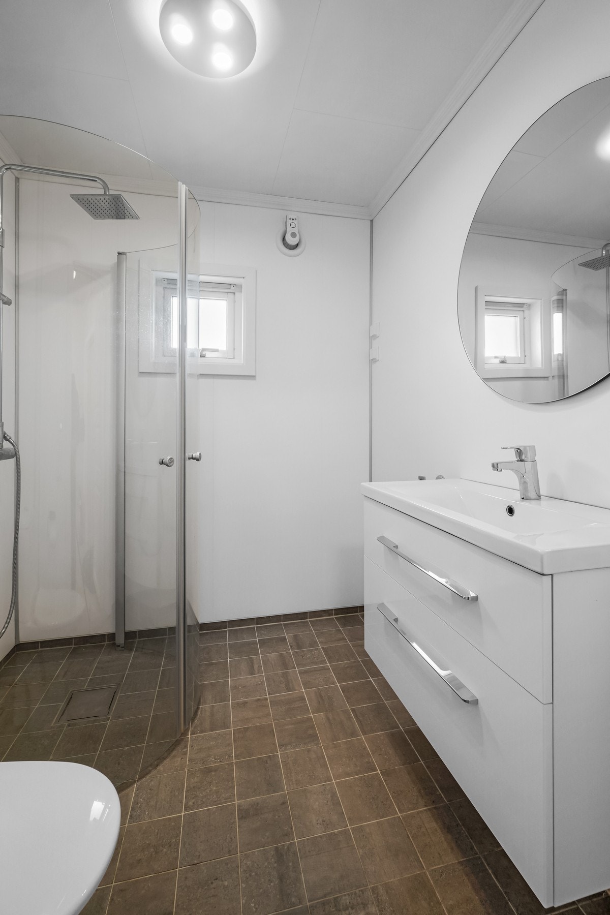 Her er det dusjhjørne med innfellbare dører, servant med overspeil, toalett og mekanisk avtrekk. Galleribilde