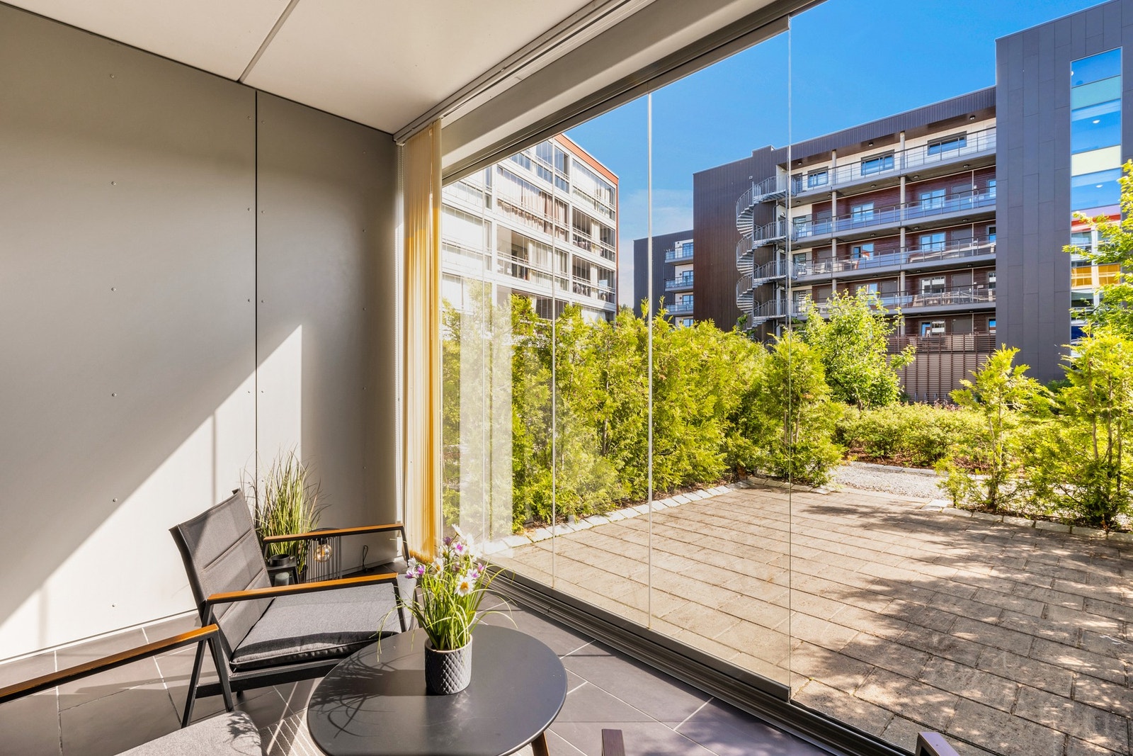 I tilknytning til den innglassede terrassen har du en romslig og steinbelagt uteplass, omkranset av høy hekk. Galleribilde