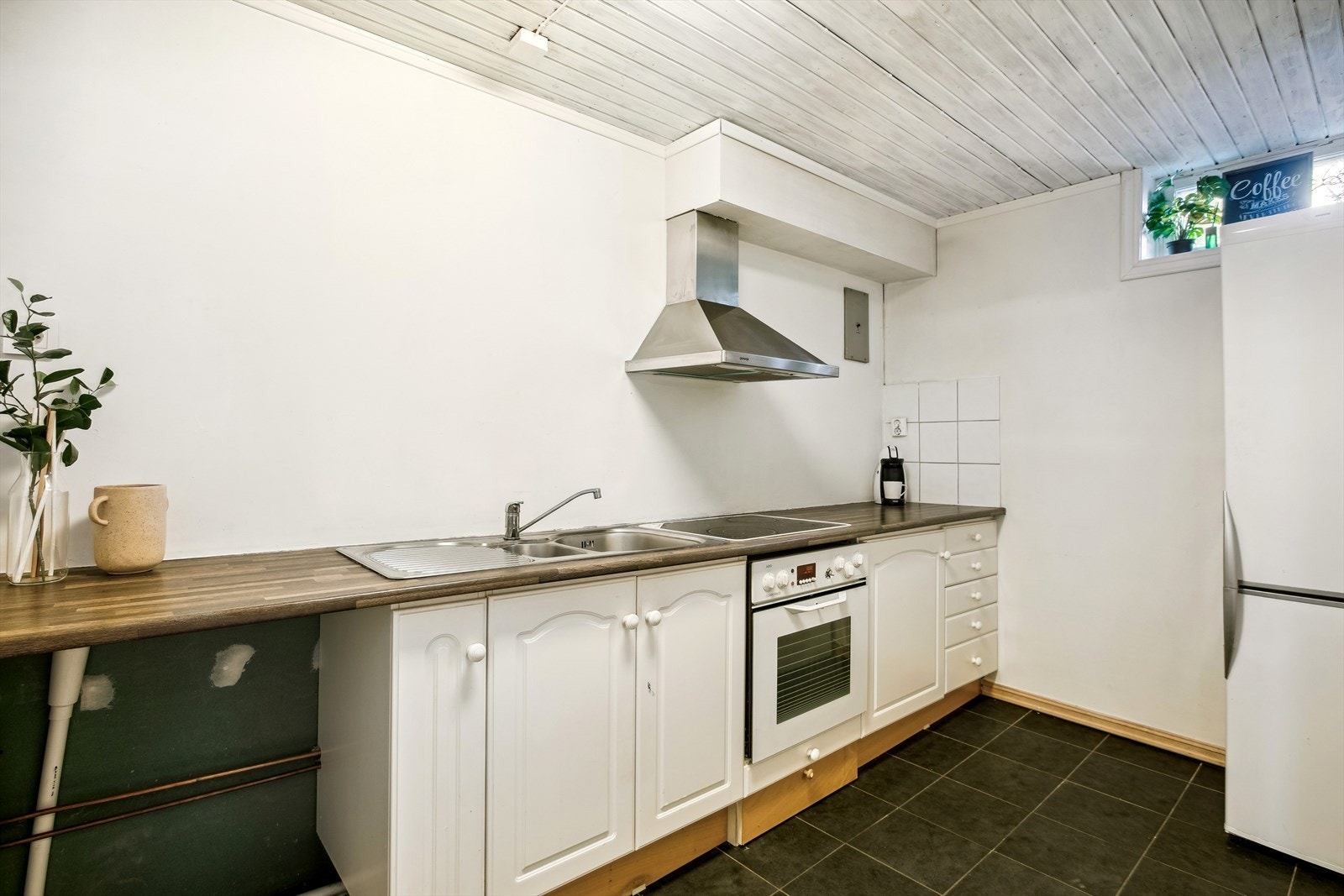 Kjøkkenet har innredning med glatte fronter og benkeplaten av laminat. Det er integrert komfyr og platetopp. Galleribilde