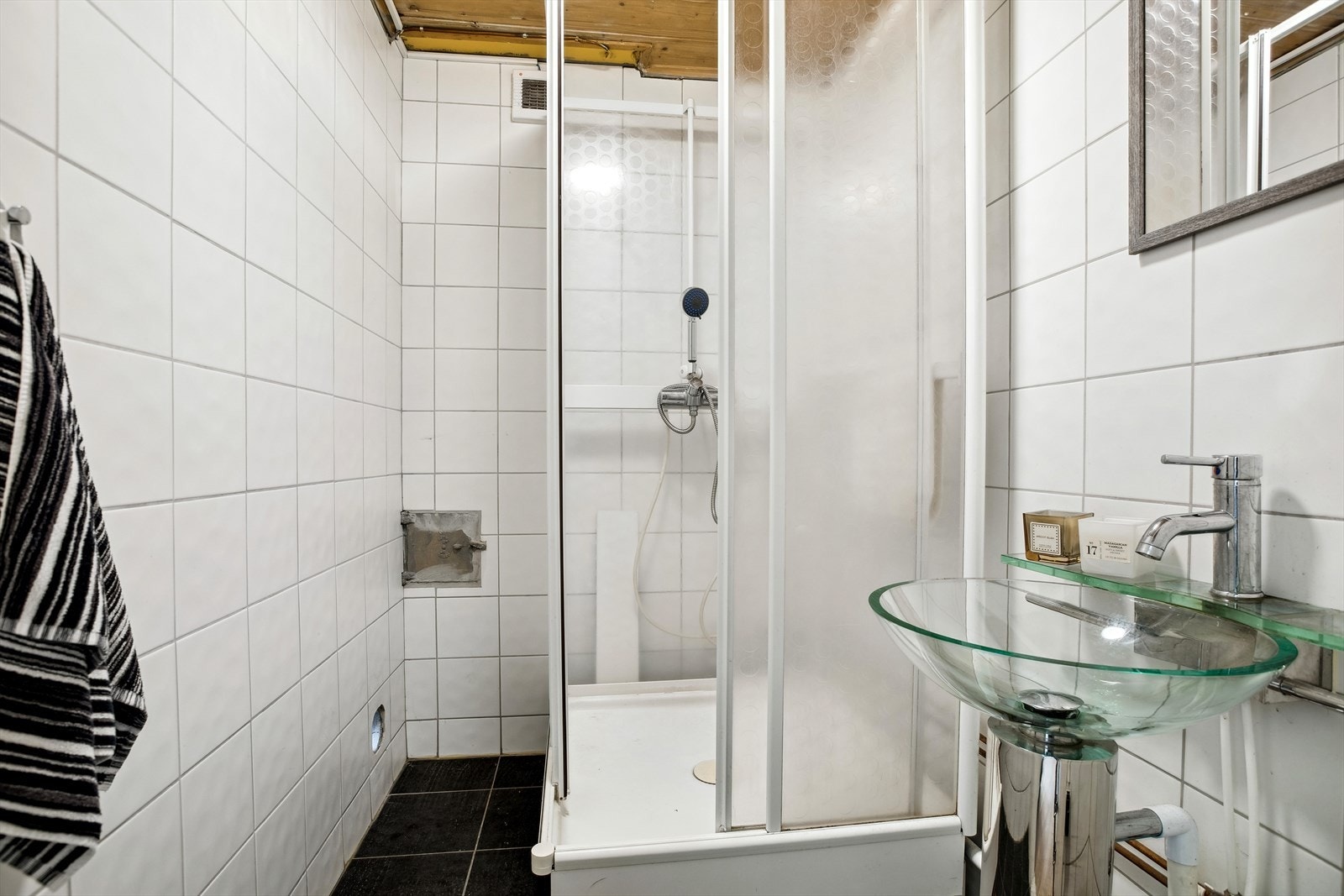 Badet har servant og dusjkabinett. Det er fliser på vegger og gulv. Badet har ikke sluk i følge takstmann. Galleribilde