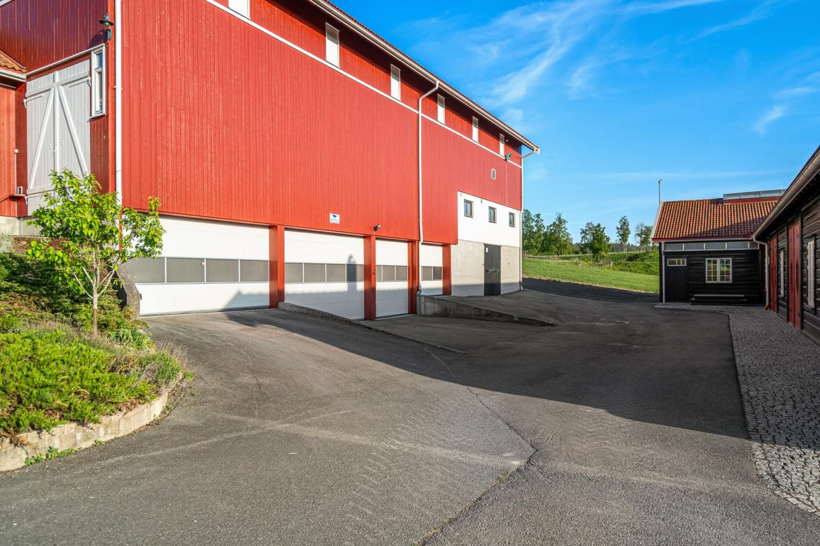 Fra nedsiden av driftsbygningen. Her er det fire store garasjer med automatisk leddporter og verksted i bakkant. Lengst bortest er det møkkakjeller (under fjøset). Galleribilde