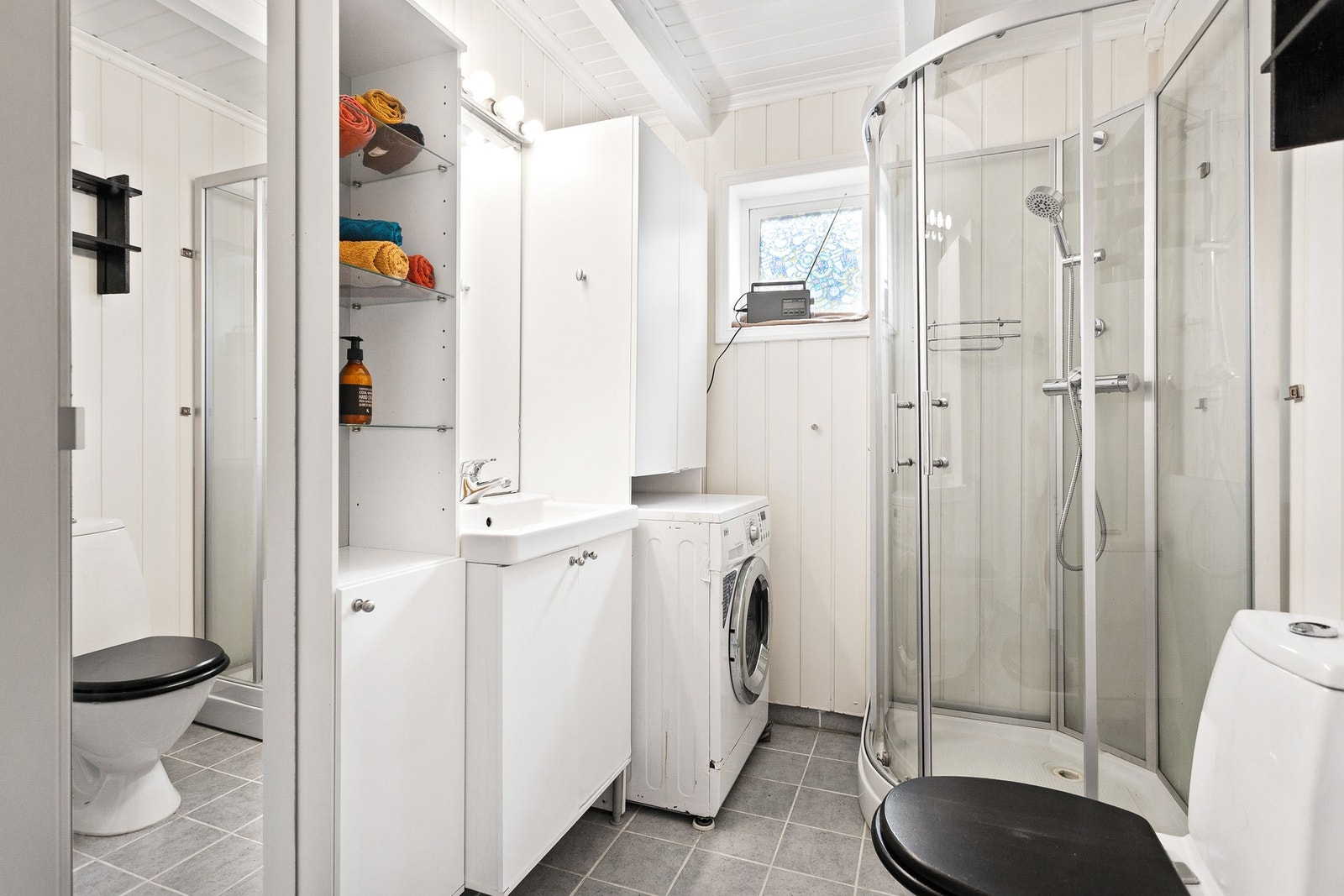 Bad med flislagt gulv og veggene har malte plater Galleribilde