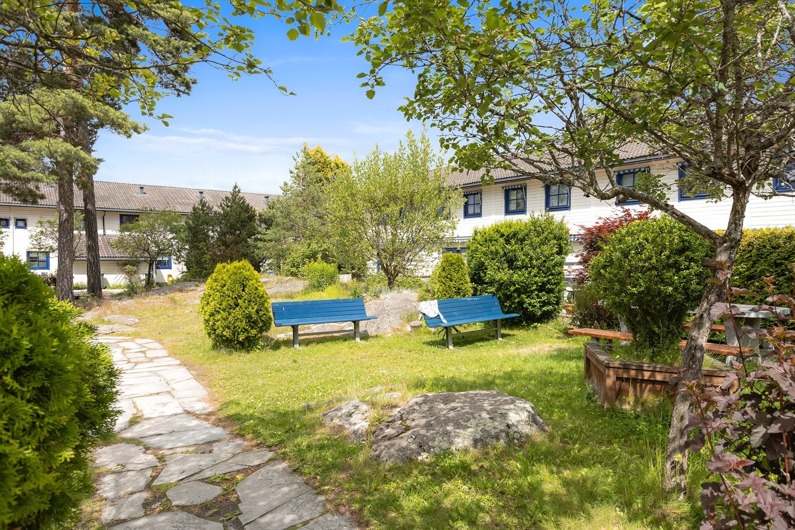 Trivelig uteområde med benker og lekeområder. Galleribilde