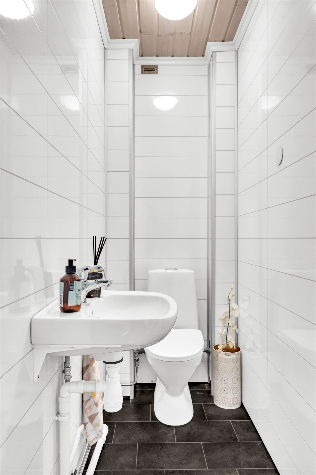Vegg i vegg med badet ligger toalettrommet innredet med toalett og servant. Galleribilde