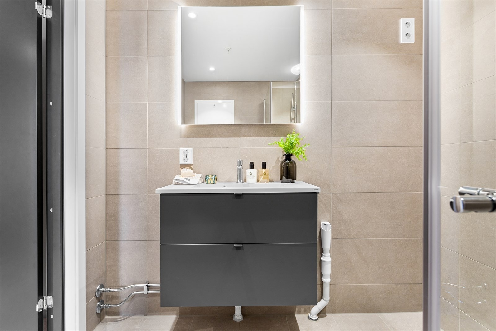 Badet er flislagt i moderne farger og har behagelig gulvvarme. Galleribilde