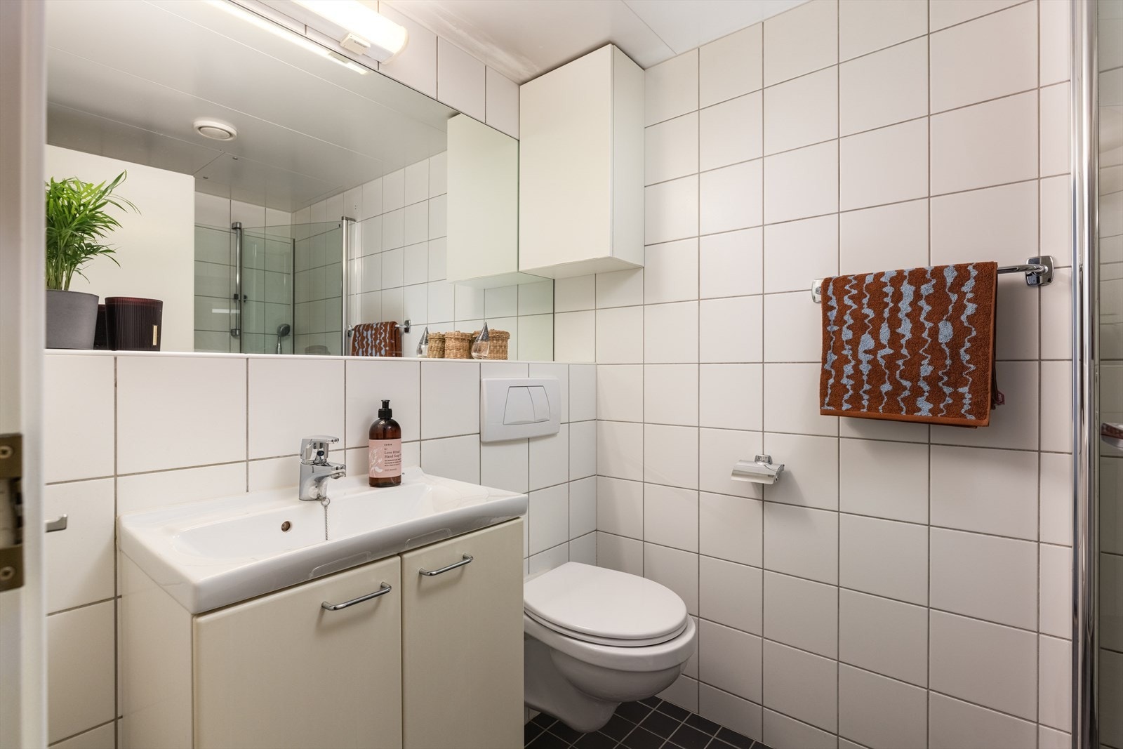 Bad fra byggeår 2004. Baderomsinnredningen er bestående av vegghengt toalett, 60 cm servant med underskap og dusjhjørne med innfellbare glassvegger. Mekanisk avtrekk. Galleribilde