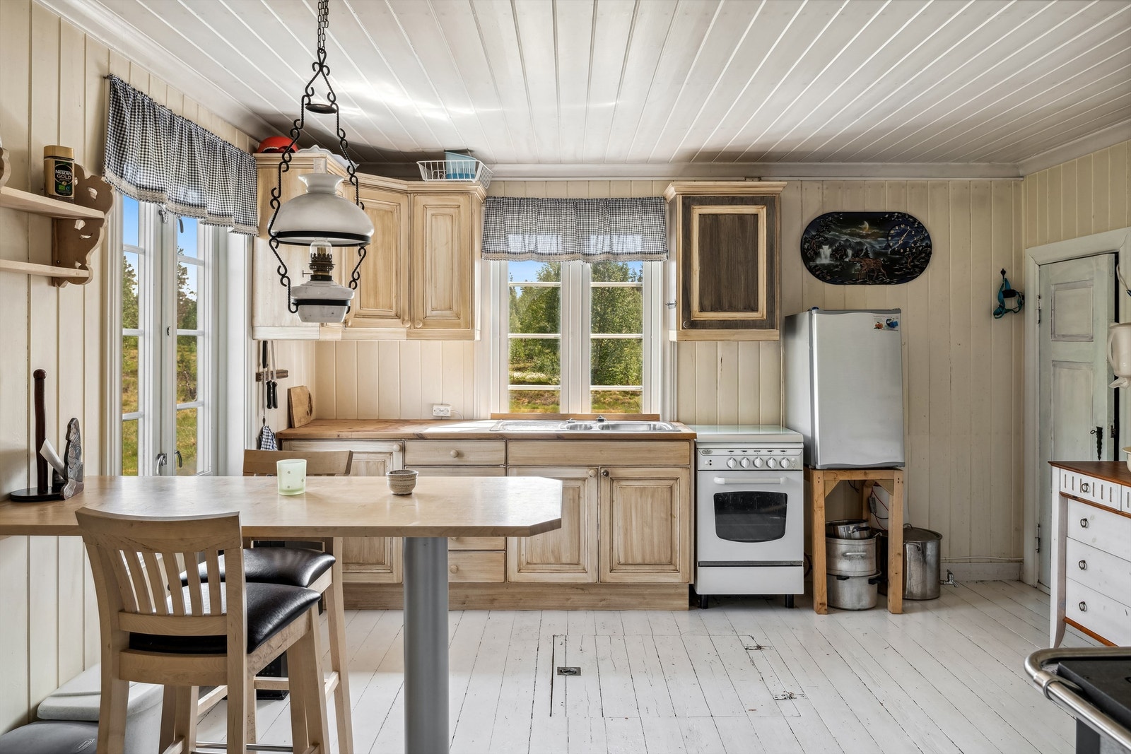 Velkommen inn på et romslig kjøkken med innredning og spiseplass. Malt original panel på vegger og tak. Spiskammers innerst til høyre i bildet. Kjellerlem til mindre kjellerrom. Galleribilde
