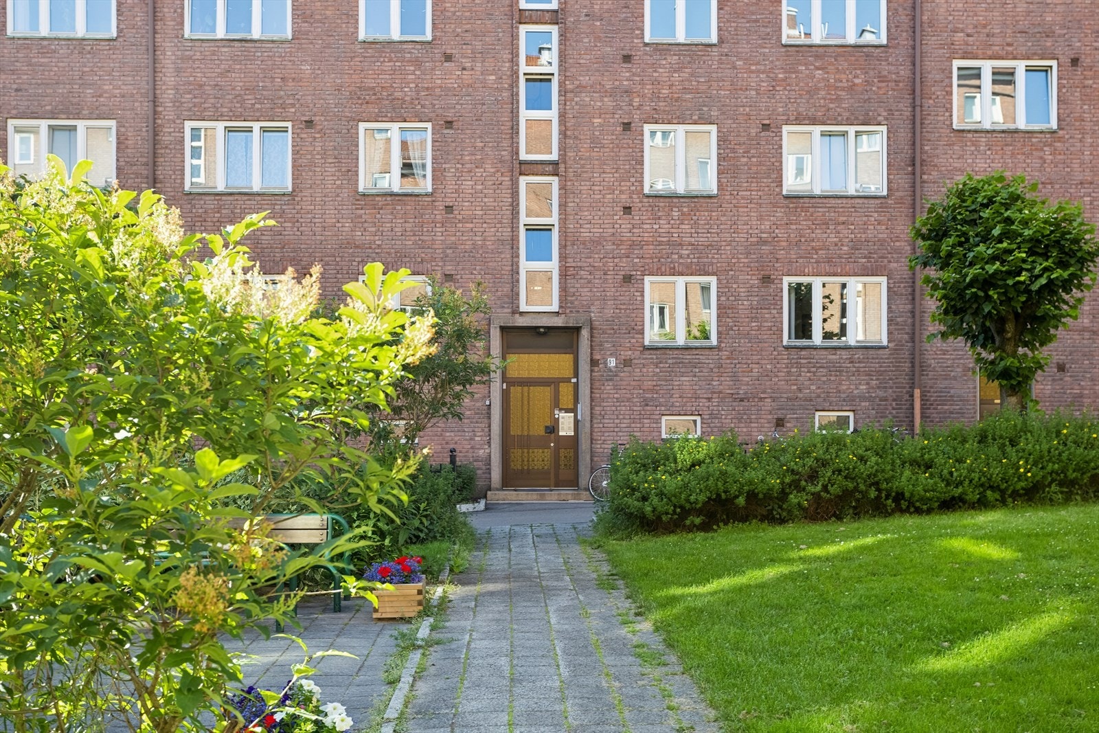 Tomten er opparbeidet med gressplener, variert vegetasjon, sittegrupper og parsellhage. Galleribilde