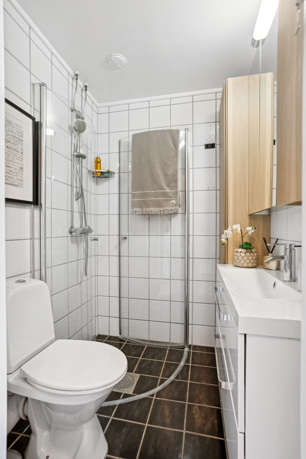 Badet er utstyrt med nedfelt servant, toalett og dusjvegger/hjørne. Galleribilde