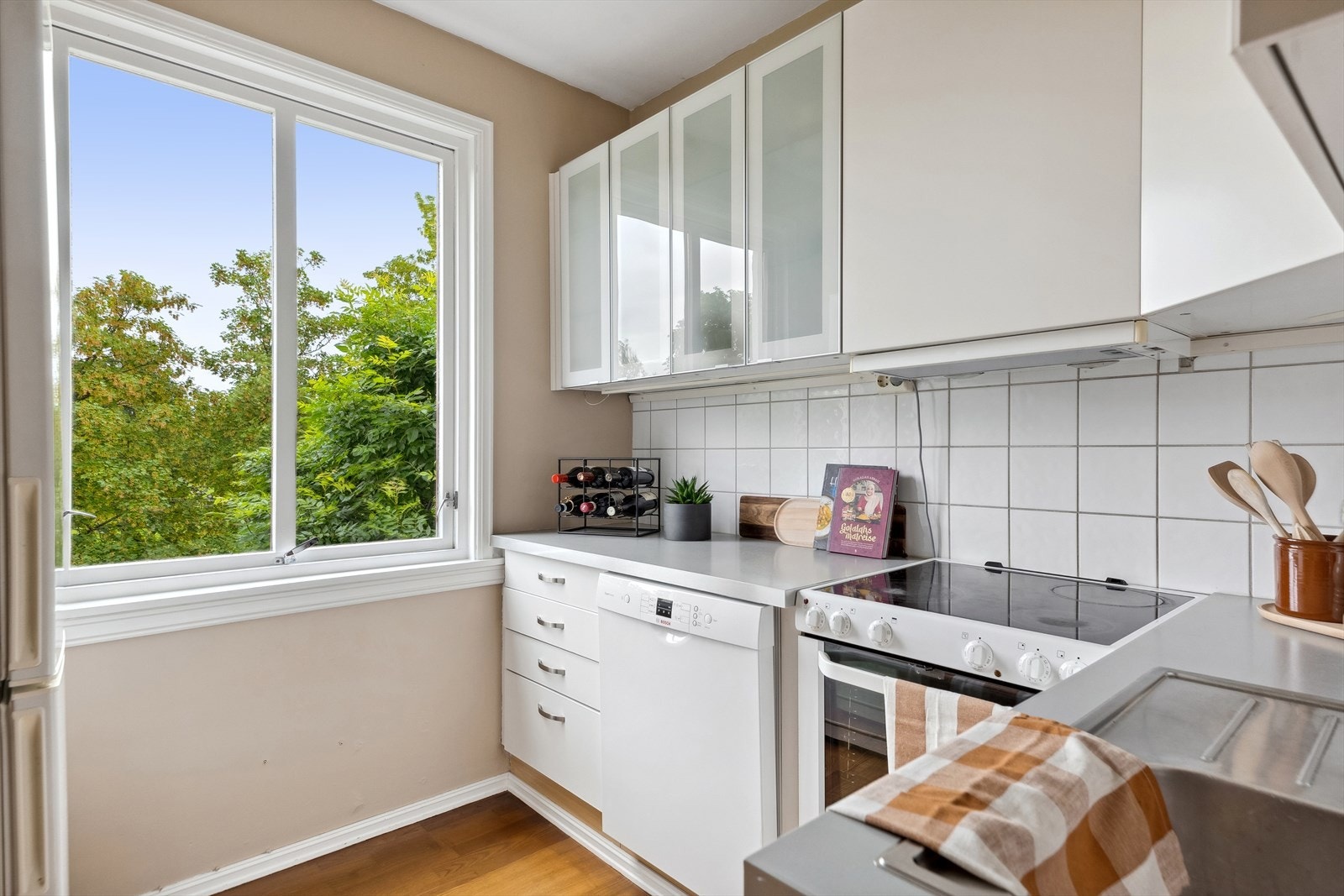 Tidløst kjøkken i hjørneform med mye oppbevaringsplass. Galleribilde