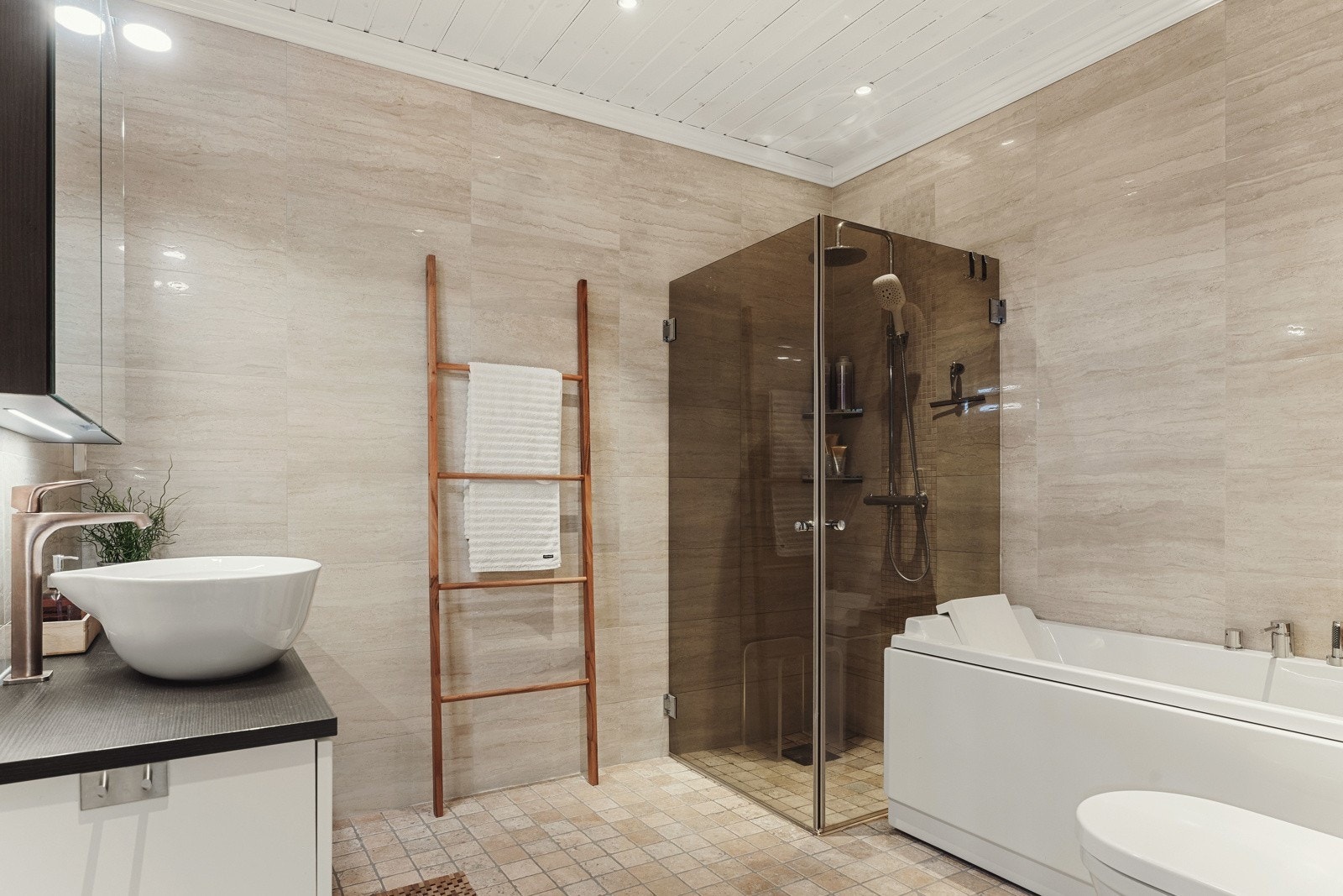 Flott flislagt bad med marmorgulv, pen innredning og badekar Galleribilde