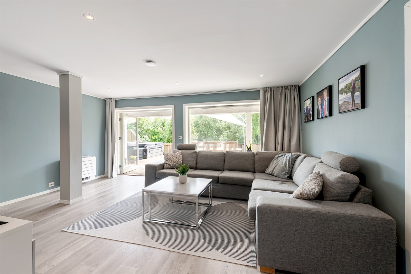 Kjellerstue med laminat på gulv,, malte vegger og tak med noe innfelte spotter. Store vindusflater og skyvedør ut til stor markterrasse mot syd Galleribilde