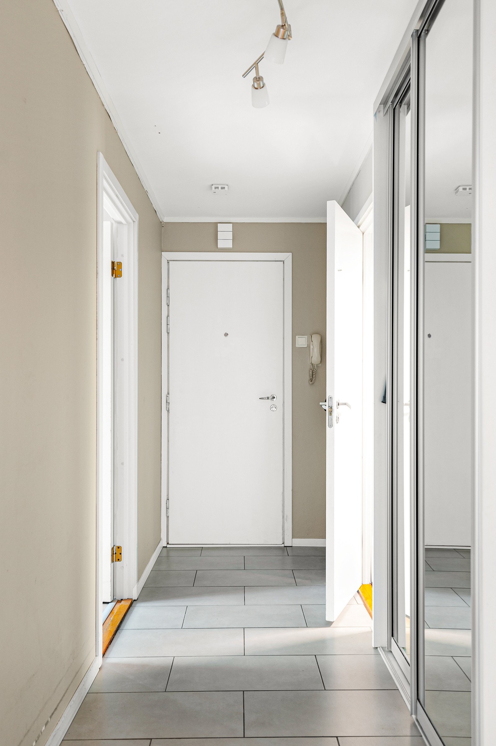 Entré med adkomst til bad og leilighetens tre soverom. Gangen er innredet med en skyvedørsgarderobe for oppbevaring av yttertøy. Galleribilde