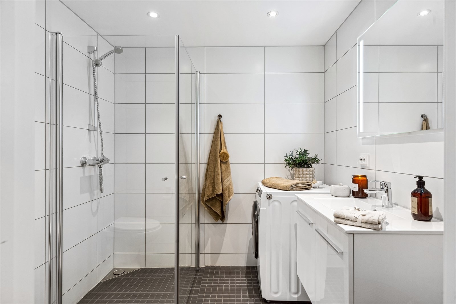 Dagene får en god start på et helfliset bad med gulvvarme og downlights. Galleribilde