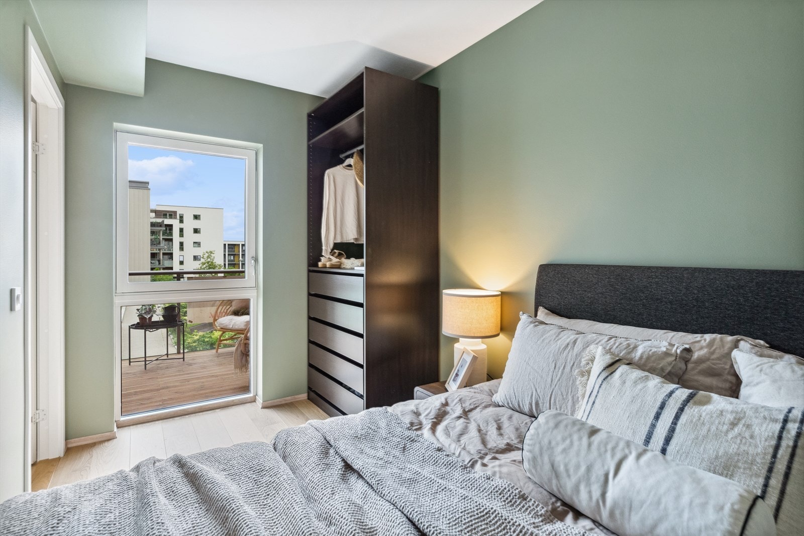 På soverommet står det et åpent garderobeskap med skuffer, hyller og en stang for oppheng. Galleribilde