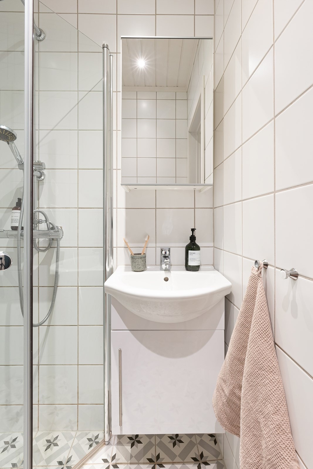 Badet består av servant, dusj og toalett. Plass til oppbevaring i speilskap og underskap. Galleribilde