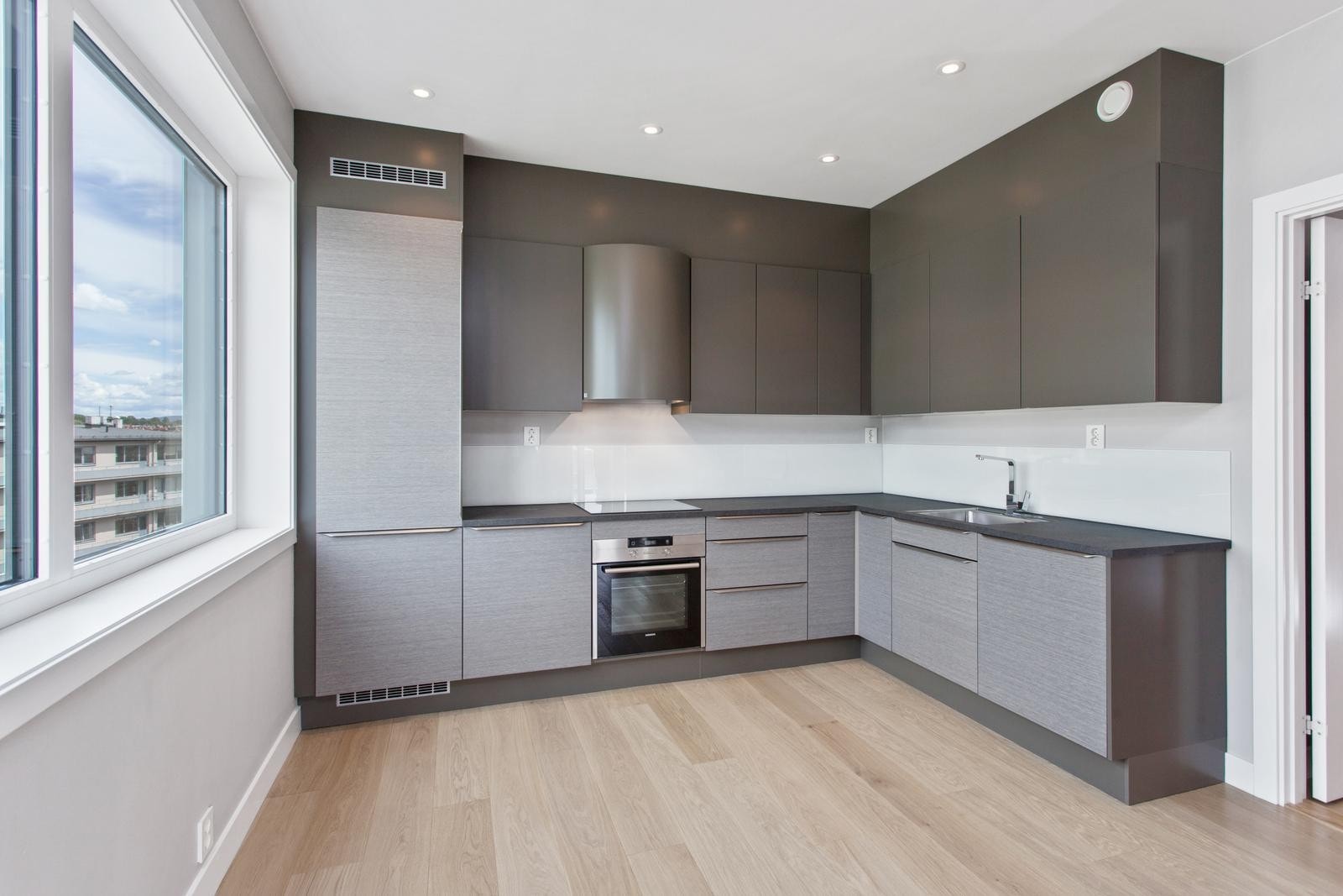 Lekkert kjøkken med integrerte hvitevarer Galleribilde