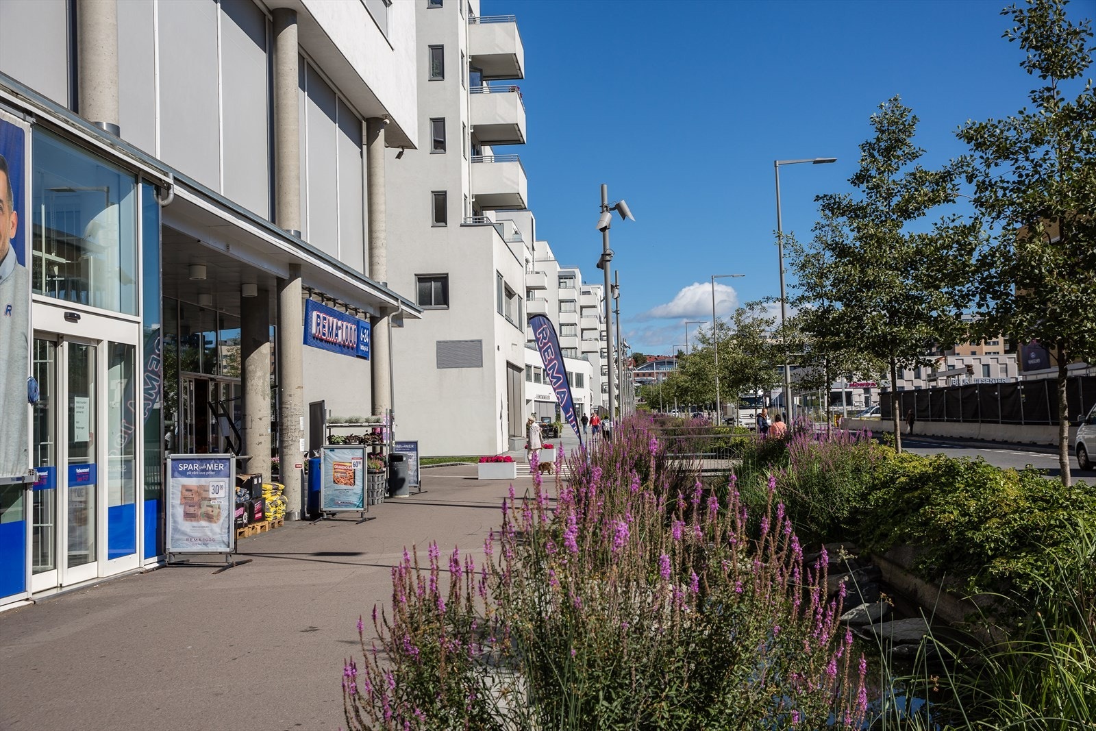 På Ensjø finner du også en velassortert Rema1000. Her sildrer bekken idyllisk langs gateløpet Galleribilde