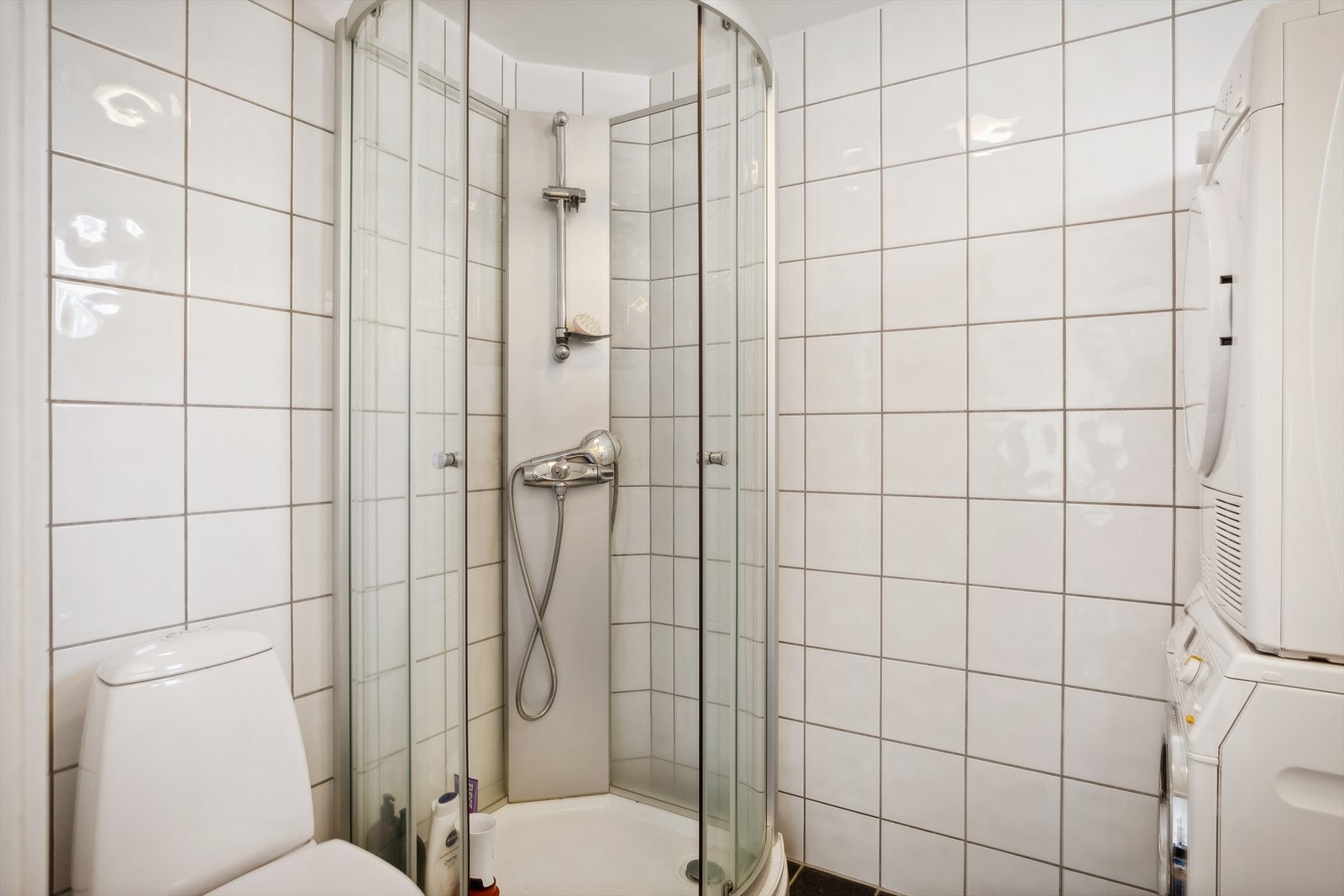 Lyst, flislagt bad med opplegg til vaskemaskin. Galleribilde