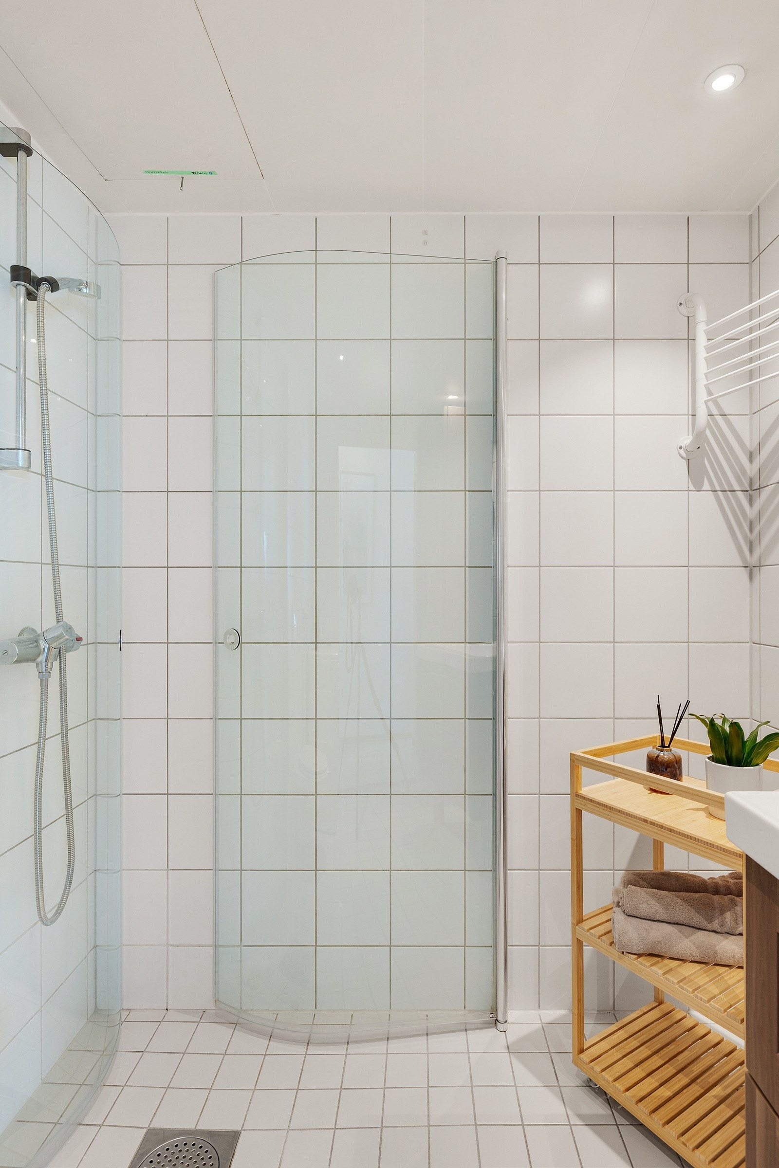 Badet har også dusjnisje med innfellbare dører og opplegg for vaskemaskin. Varme i gulv og downlights i himling. Galleribilde