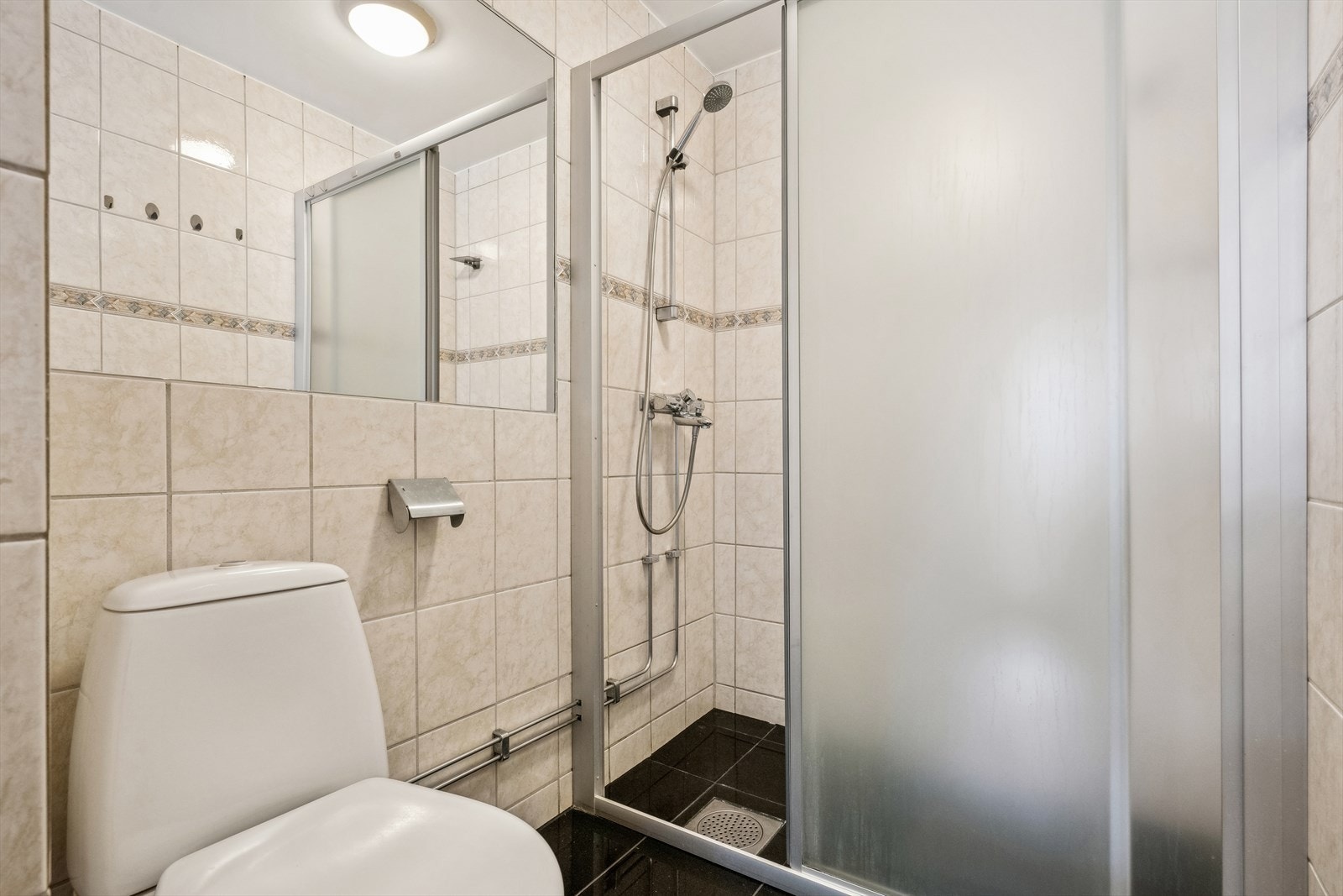 Det er gulvstående WC og dusjnisje med skyvedører Galleribilde
