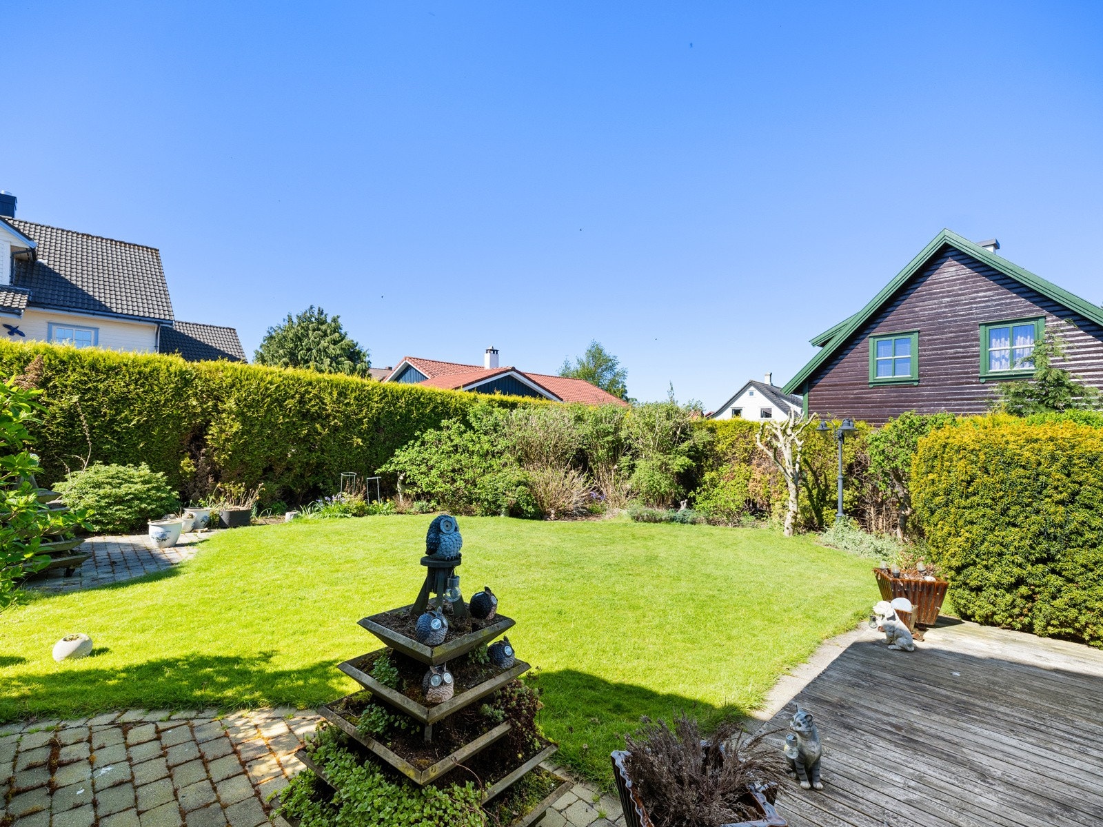 Tomten er meget pent opparbeidet med plen og frodige prydbusker. Galleribilde