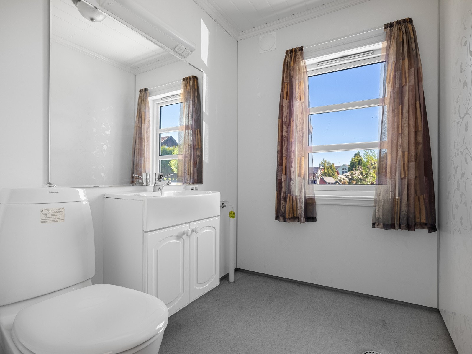 Wc-rommet ligger praktisk til ved entreen. Rommet har belegg på gulv og baderomsplater på vegg. Det er ellers en baderomsinnredning med hvite profilerte fronter og speil. Rommet er utstyrt med toalett og opplegg til vaskemaskin. Galleribilde