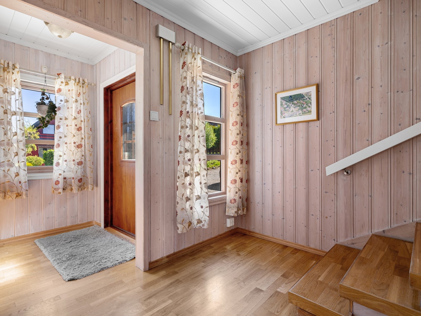 Fra overbygd inngangsparti kommer man inn til inn til en romslig entré med 3-stavs parkett på gulv og panel på veggflater. Galleribilde