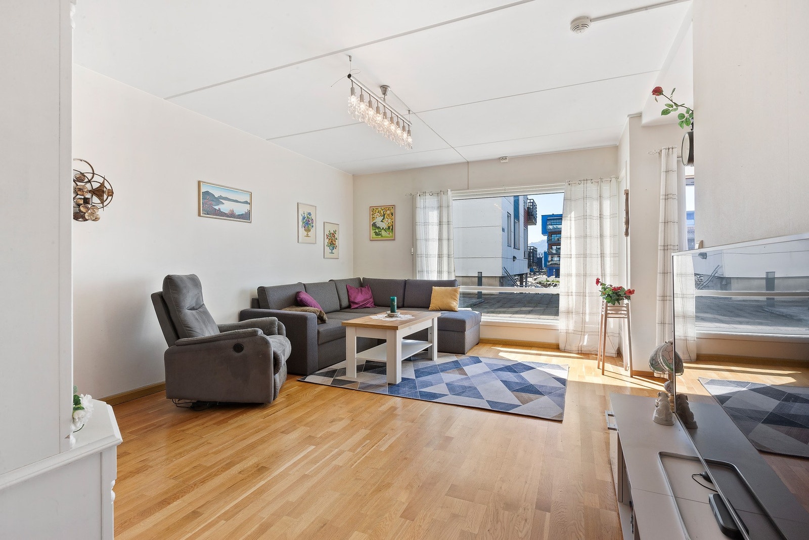 De store vinduene gir leiligheten rikelig med dagslys, og muligheten til å se på bylivet rett fra stua. Galleribilde