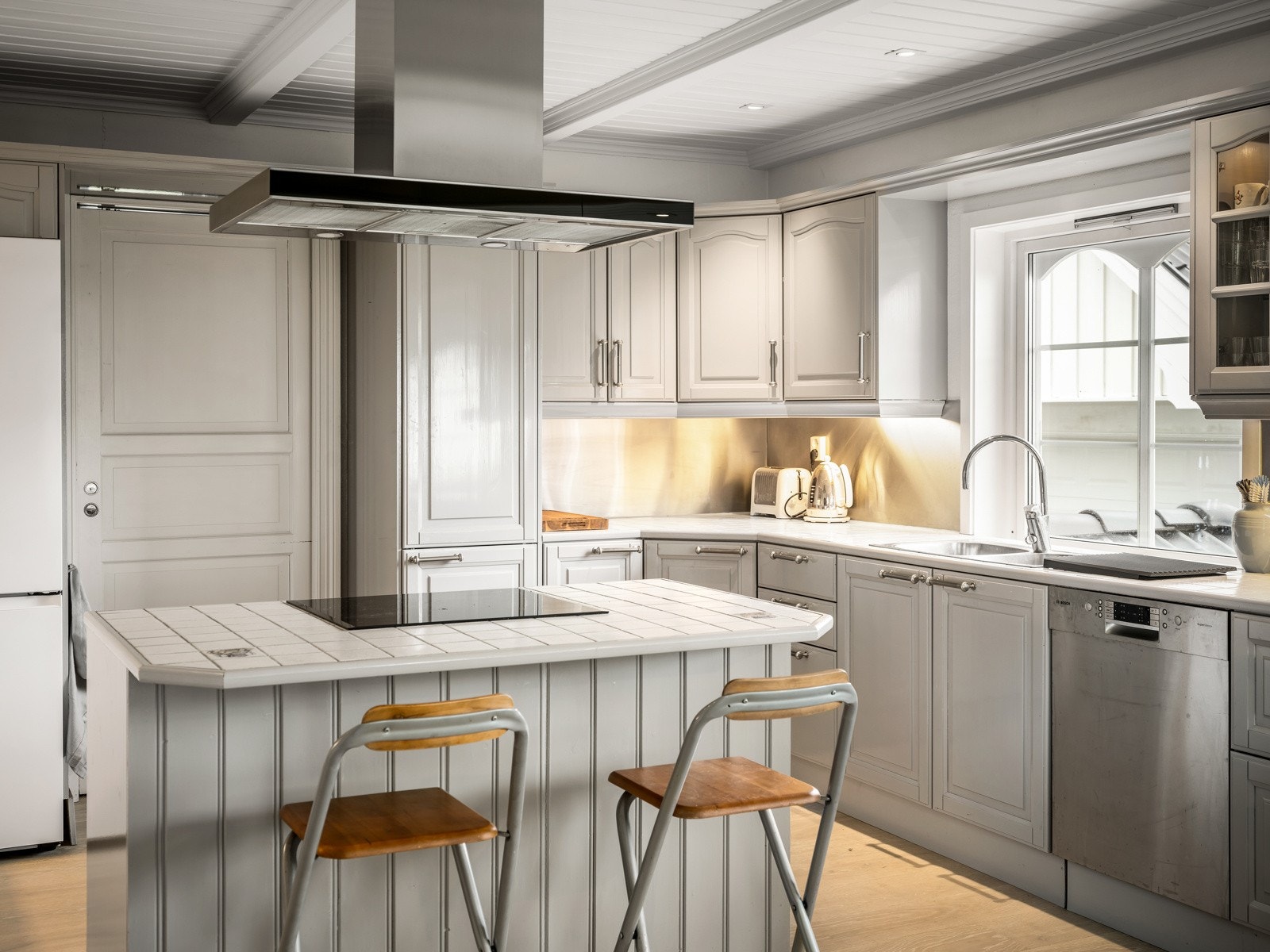 Stekeovn og induksjonstopp er som sagt integrert i kjøkkenøyen, og kjøkkenet har også opplegg for vaskemaskin og plass til kjøle/fryseskap. Fra kjøkkenet er det dør videre inn til vaskerommet, og herfra ut til entreen/hallen. Galleribilde