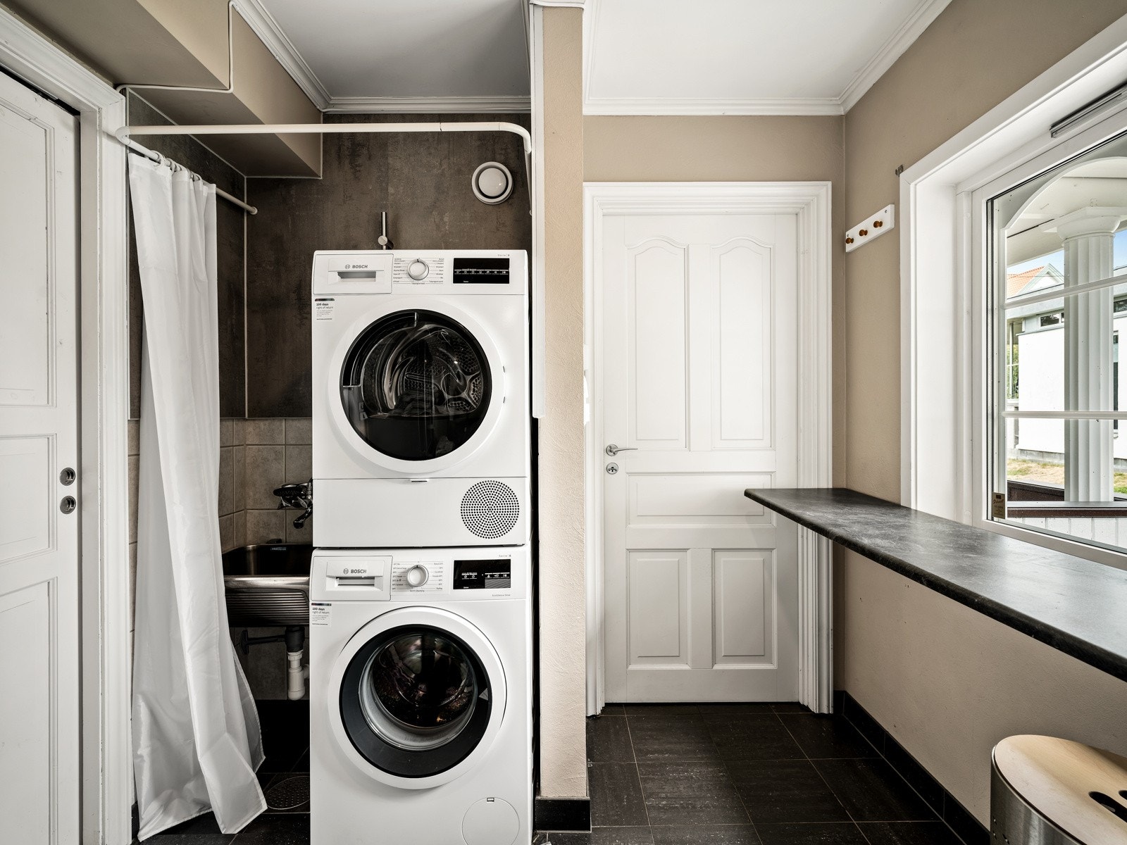 Vaskerommet ligger rett ved og har fliser på gulvet, gulvvarme, våtromsplater/malte flater på veggene, innredning, utslagsvask og opplegg for vaskemaskin. Galleribilde