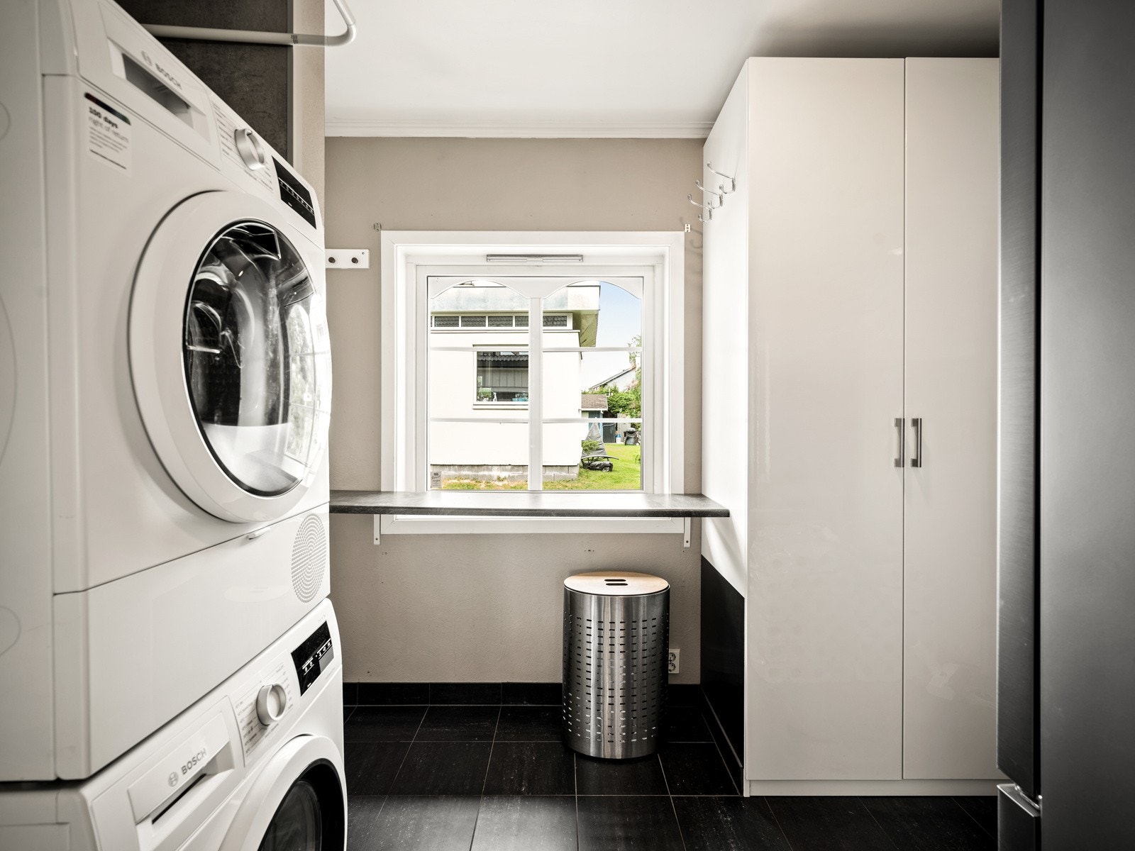 Vaskerommet ligger rett ved og har fliser på gulvet, gulvvarme, våtromsplater/malte flater på veggene, innredning, utslagsvask og opplegg for vaskemaskin. Galleribilde