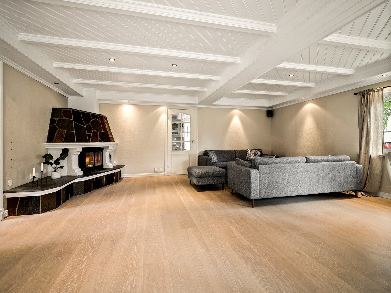 I det ene hjørnet er det montert en stemningsfull peis med innsats, og rommet har også varmepumpe. Fra stuen er det dør med glassfelt inn mot kjøkkenet. Galleribilde