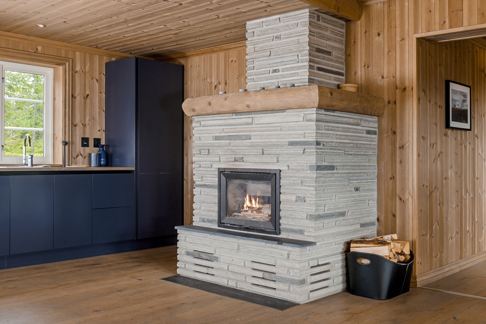 Flott, muret peis med innsats gir god varme og skaper hyggelig stemning. I tillegg varmes hytta opp med elektrisitet. Galleribilde