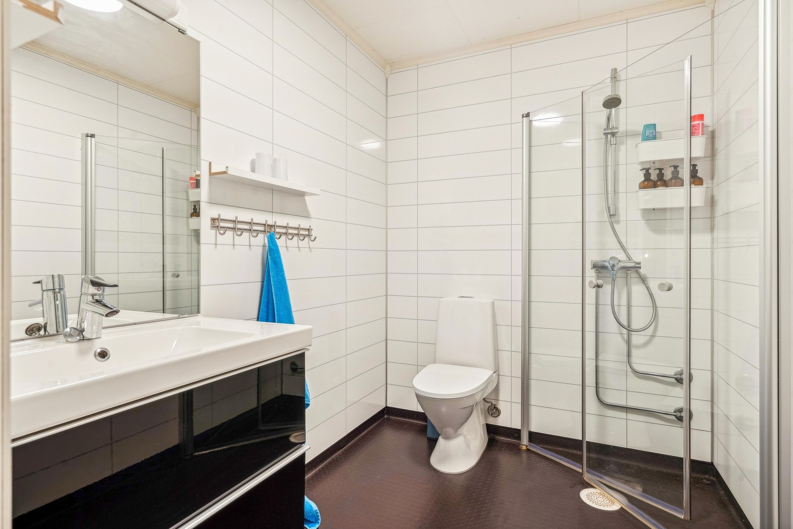 Badet fremstår med våtromsbelegg m/ nedstøpte varmekabler og baderomsplater på vegg. Galleribilde