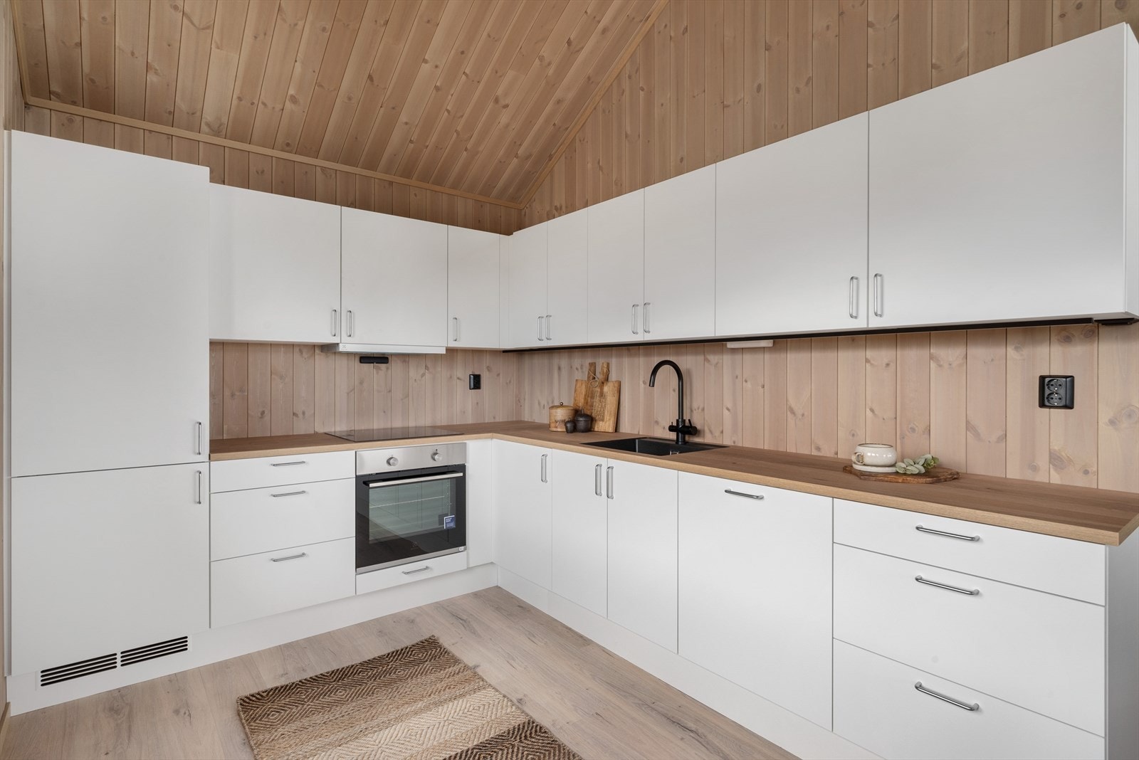 Den funksjonelle kjøkkeninnredningen har glatte fronter og rikelig med oppbevaringsplass. Galleribilde