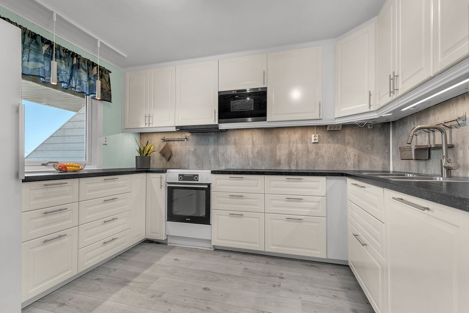 Pent og tidløst kjøkken med store arbeidsflater Galleribilde