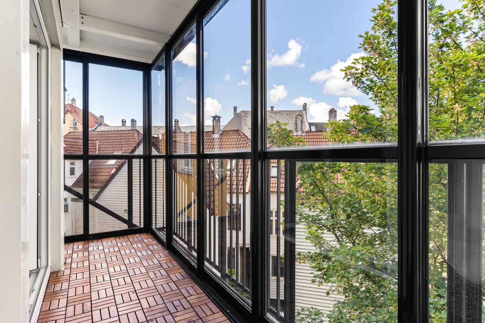 Fra stuen har man direkte utgang til leilighetens innglasset balkong. Galleribilde