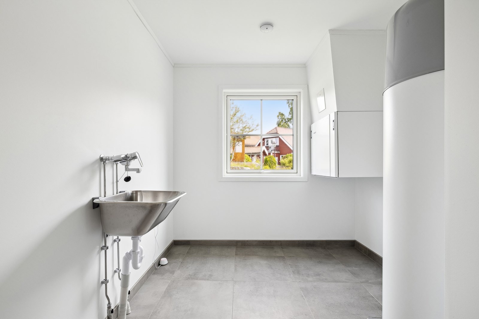 Vaskerom med skyllekum og opplegg for vaskemaskin - her er også boligens varmtvannsbereder plassert Galleribilde