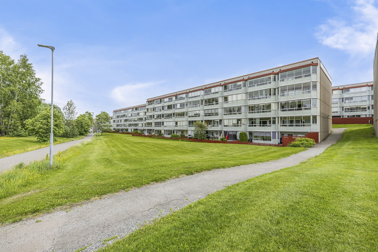 Tomten er opparbeidet med plen og beplantning. Det er p-plasser, felles p-hus og gjesteparkering på området. Galleribilde