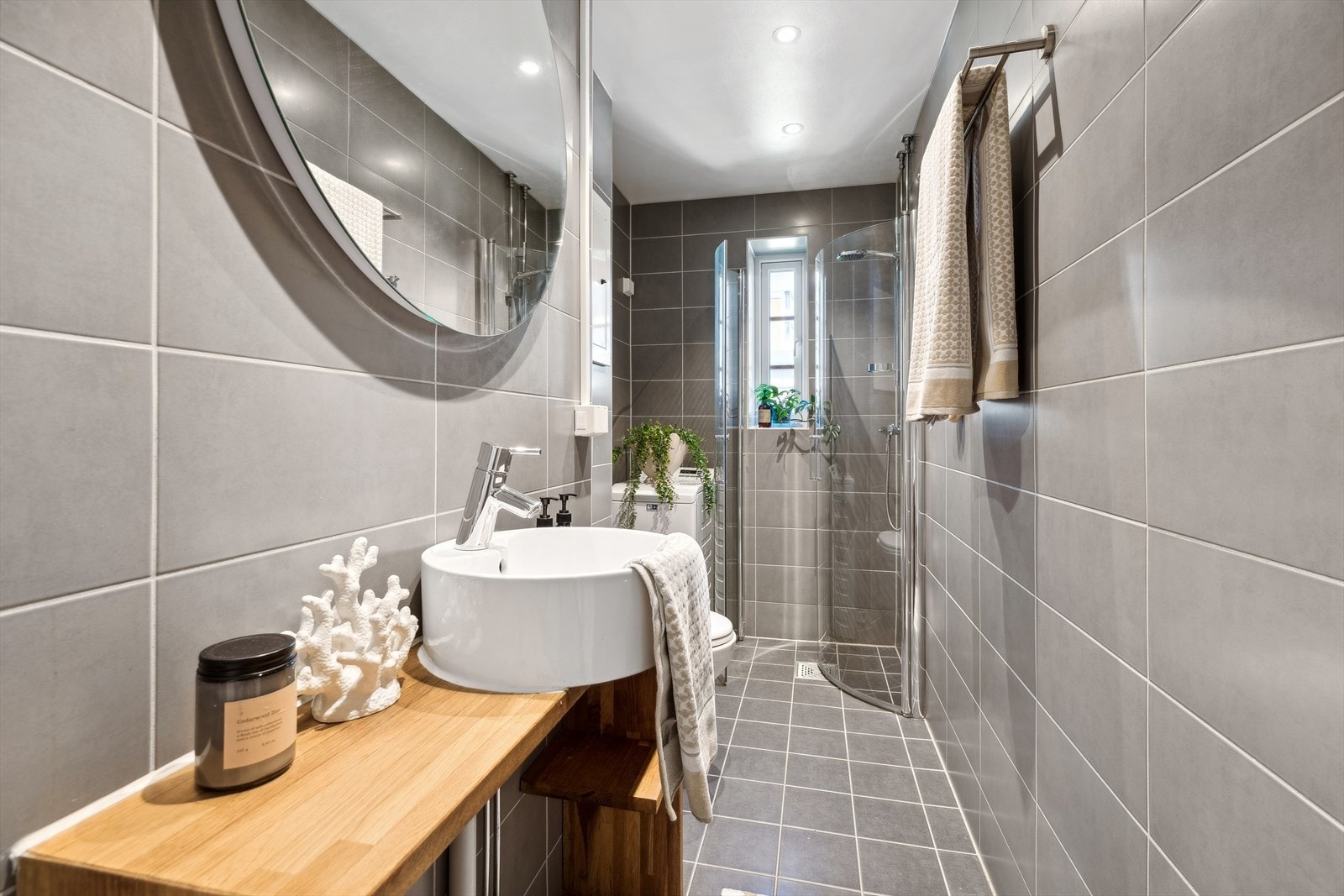 Bad/wc består av vegghengt wc, servant, speil, inn-/utadslående dusjdører og opplegg for vaskemaskin Galleribilde