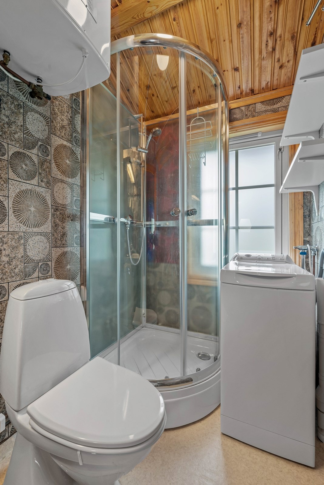 Mellom stuen og kjøkkenet er det et effektiv utnyttet bad med dusj, wc og uttak til vaskemaskin. Galleribilde